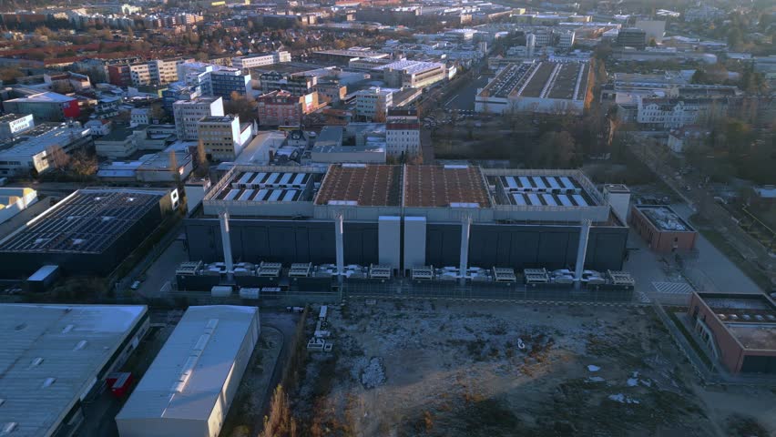 Large big data center building with advanced cooling systems, providing digital infrastructure in a city Berlin. Smooth aerial view drone camera pointing down
