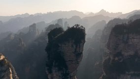 Drone aerial of Zhangjiajie Avatar mountains bathed in golden sunrise light with mist layers, dreamy China scenery - Powered by Shutterstock - Get 15% off with code: PIKWIZARD15