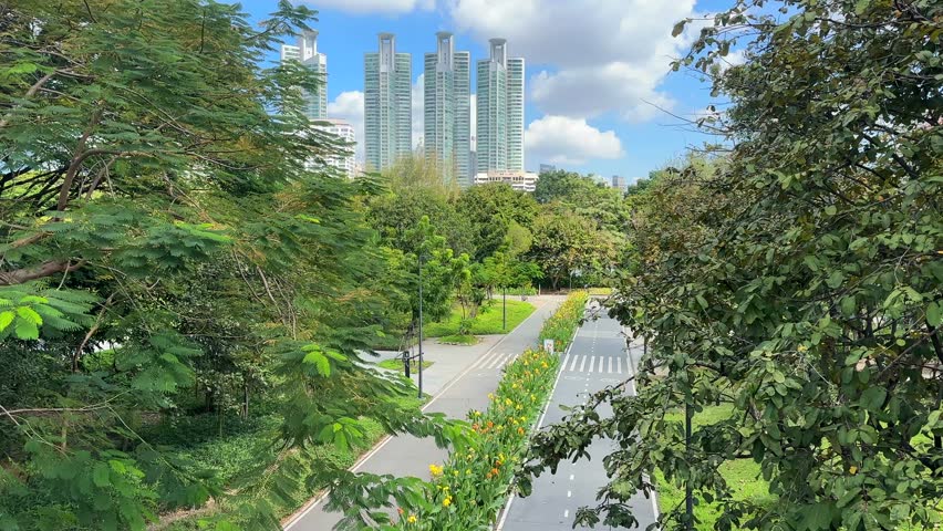 Bangkok Skyscrapers Skyline View from Benchakitti Park – City Buildings Behind Lake and Green Nature, Central Bangkok Thailand, Southeast Asia Urban Landscape Video