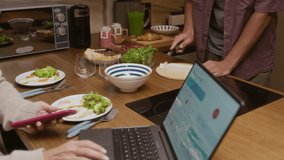 Cropped shot of couple enjoying breakfast at home, man cooking healthy meal while woman using laptop with calendar widget on screen, showing balanced morning routine - Powered by Shutterstock - Get 15% off with code: PIKWIZARD15