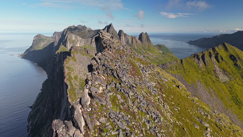 Aerial view of Segla mountain peak and ocean near coastal area in Norway during daytime with clear sky. Fly around mountain Segla, Senja island