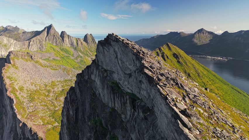 Aerial view of Segla mountain peak and ocean near coastal area in Norway during daytime with clear sky. Fly around mountain Segla, Senja island