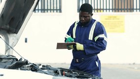 African mechanic recording car diagnostics on a clipboard during routine maintenance in his workshop - Powered by Shutterstock - Get 15% off with code: PIKWIZARD15