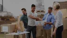 Four volunteers packing donations, man reaching orange starting sorting, HUD expanding over team. Warehouse, teamwork, collaboration, supplies, charity, organization, overlay - Powered by Shutterstock - Get 15% off with code: PIKWIZARD15