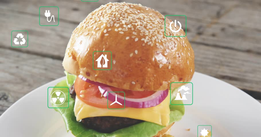Green icons fading in from edges floating over sesame burger camera pulling back revealing eco cost. Sandwich, fries, tabletop, overlay, symbols, savory, advertising