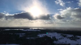 High drone rising and pulling back with bright sun halo above snowy forest landscape. - Powered by Shutterstock - Get 15% off with code: PIKWIZARD15