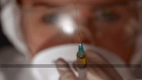 Nurse checking medical syringe with amber liquid, priming, tapping, forcing drops with scan lines. Needle, droplets, macro, closeup, sterile, clinic, laboratory - Powered by Shutterstock - Get 15% off with code: PIKWIZARD15