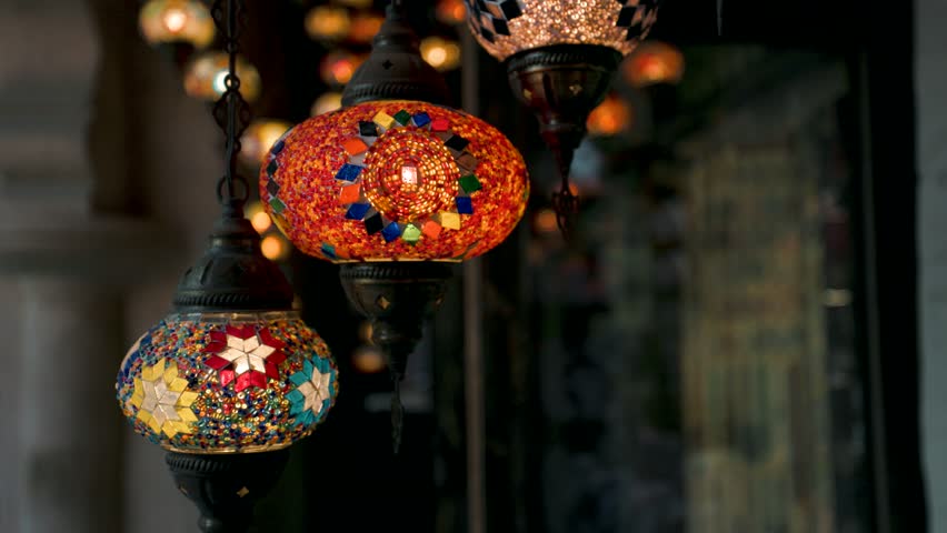 Decorative Arabic Turkish lanterns in slow motion, glowing softly and hanging in a traditional setting. Ideal for Ramadan, Eid al Fitr, Eid al Adha, and Islamic holiday projects. 4K Footage.