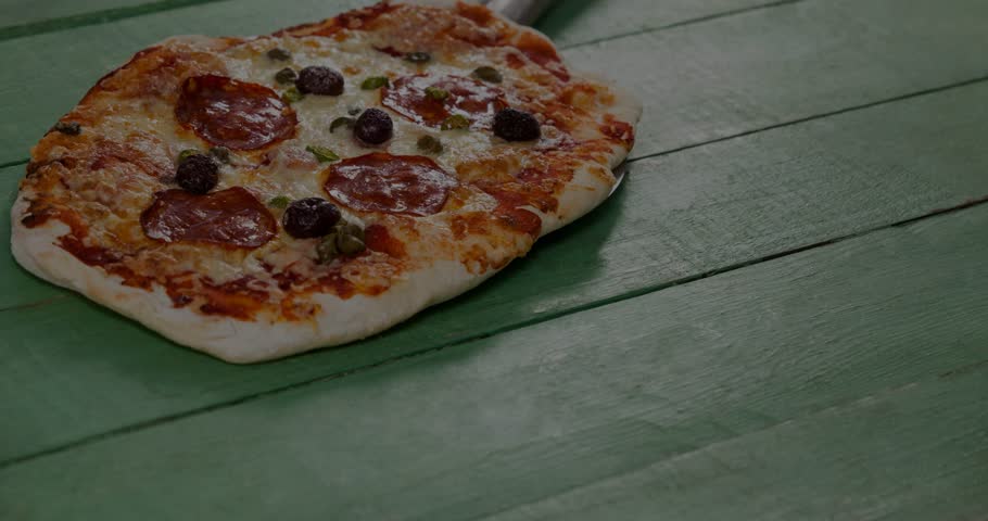 On start visualizer bars sliding, colorful and pulsing across green table as audio cue, pizza still. Flatbread, waveform, closeup, olives, pepperoni, peppers, toppings