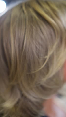 Female hand moves blond hair. Beautiful long hair.