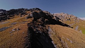 Aerial view of a FPV UAV pursuing high in the mountains on a sunny day. Tracking and pursuing a self-assembled drone. - Powered by Shutterstock - Get 15% off with code: PIKWIZARD15