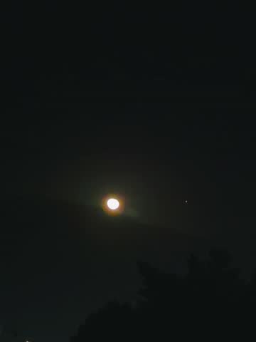 The bright object is the Moon, and the smaller, bright speck nearby is the planet Venus.