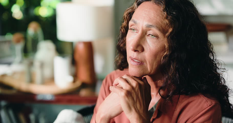 Thinking, depression and mature woman in home with loneliness, stress or remember past with regret. Reflection, sad and person in living room with anxiety for mental health, nostalgia and flashback