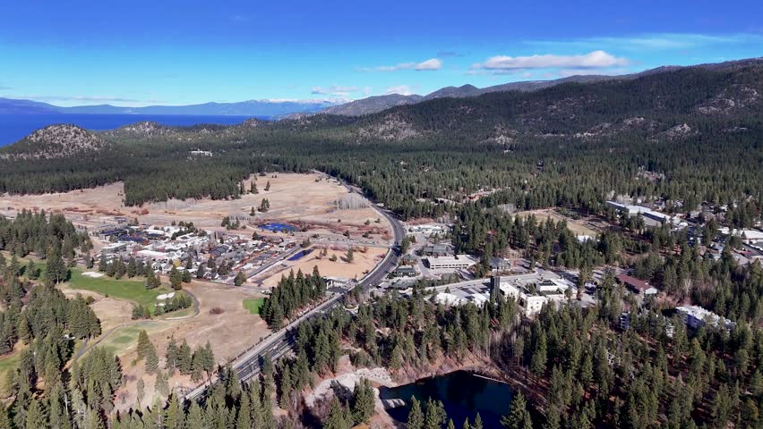 Aerial view of South Lake Tahoe highway passing through pine forest and dry meadow