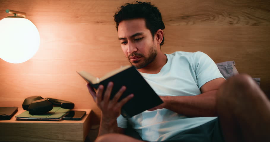 Man, praise and reading bible in bedroom, scripture and Christian with belief for religion and home. Catholic, faith and person with book for spiritual guidance, salvation and holy literature on bed