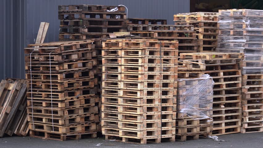 High stacks of wooden pallets in outdoor industrial yard