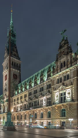 Building of the Hamburg City Hall night timelapse hyperlapse, the seat of government of Hamburg, located in the Altstadt quarter in the city center. Front view from the main square under a cloudy sky