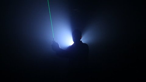 silhouetted person waves Light Saber 