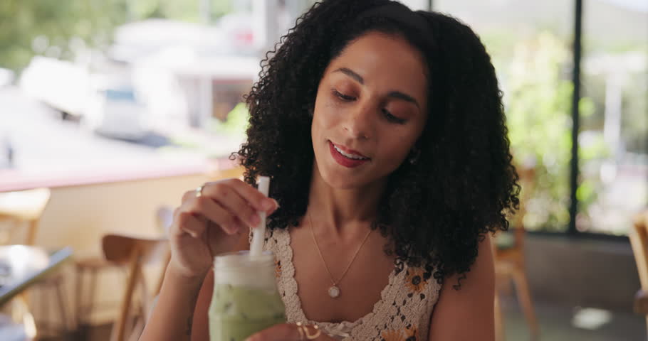 African woman, stirring and drink at cafe with iced matcha latte, refreshing smoothie and mix flavor. Smile, female person and green milkshake for healthy beverage, nutrition benefits and weight loss