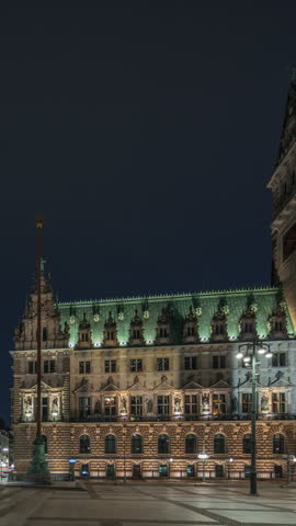 Panorama showing illuminated building of the Hamburg City Hall night timelapse, the seat of the government of Hamburg, in the Altstadt quarter in the city center. Front view from the main square