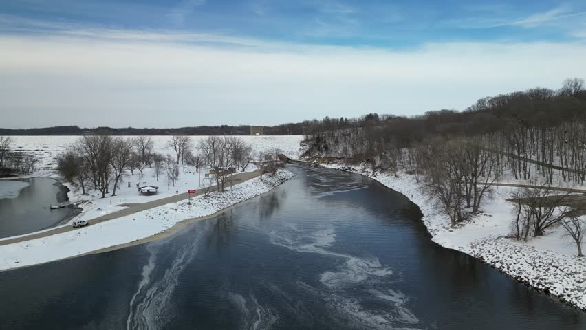 Flying towards the Iowa River damn at Coralville Iowa on a snowy winters day. 4k, drone