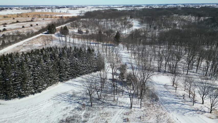 An ideal outdoor exploration location, Kent Park in Iowa, covered with snow is a beautiful sight in the cold winter air of February. Ready to host a variety of winter time sports. 4k, drone, flying