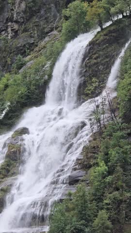 Majestic Cascata di Foroglio waterfall cascading down rocky cliffs in Valle Bavona, Switzerland. Powerful alpine nature surrounded by forest. Ideal for travel ads.