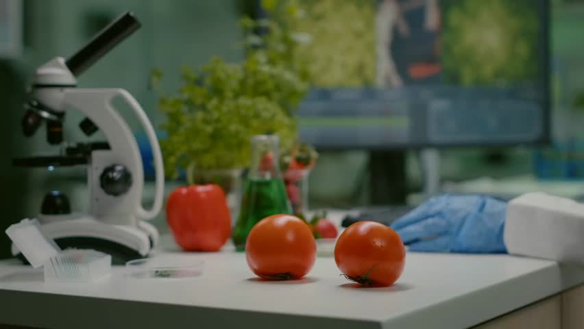 Close-up of a chemist injecting an organic tomato with pesticides in a laboratory, demonstrating food testing, chemical research, and agricultural safety analysis.