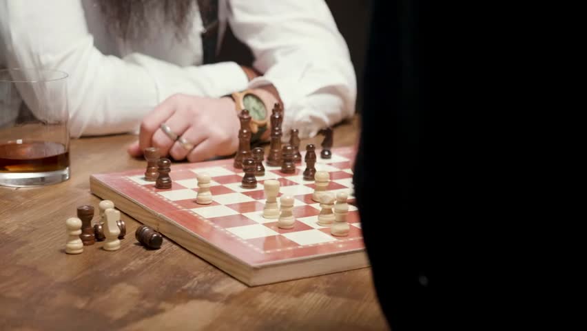 Parallax shot of male hands playing chess, showing a decisive checkmate moment, strategy, competition, and intellectual gameplay.