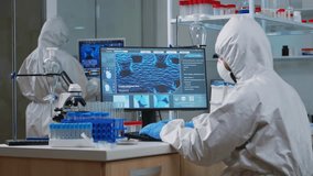 Medical scientist in PPE analyzing DNA scans and typing on a PC in a high-tech lab, studying vaccine evolution and virus development. - Powered by Shutterstock - Get 15% off with code: PIKWIZARD15