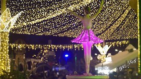 A rotating illuminated ballerina sculpture with a pink skirt spins under golden lights at the Nutcracker-themed Craiova Christmas Market. - Powered by Shutterstock - Get 15% off with code: PIKWIZARD15