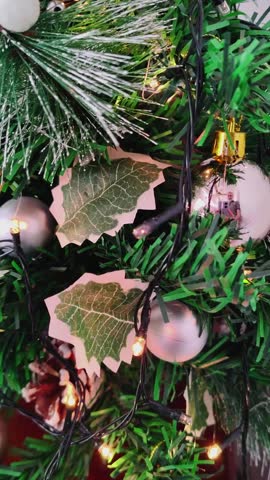 Close up video of small artificial christmas tree decorated with flashing lights and ornaments