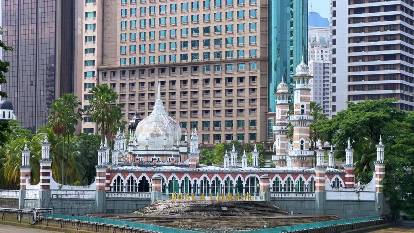 Malaysia - June 10, 2025: Panoramic view of the Masjid Jamek Sultan Abdul Samad Mosque and the confluence of the Klang and Gombak rivers with skyscrapers in the capital city of Kuala Lumpur.4К