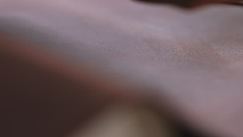 Macro hot stamping machine embossing logo into brown leather surface for handmade wallet branding