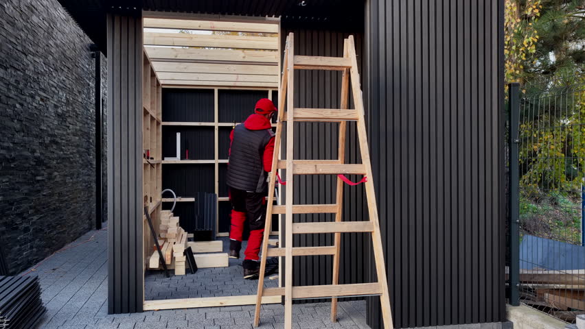 Workers construct a storage shed in a backyard using wood and tools, focusing on the structure and workspace.