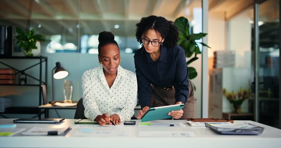 Business women, tablet and advice in office with training, mentor and review for help at night. Employees, people and coaching with journalist, feedback and technology for proposal or agency report