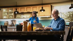 Elderly couple cheering with a jolly smile after hearing good news, sitting at kitchen table during morning routine. Aged husband and wife celebrate proud achievement in retired life. Camera B. - Powered by Shutterstock - Get 15% off with code: PIKWIZARD15
