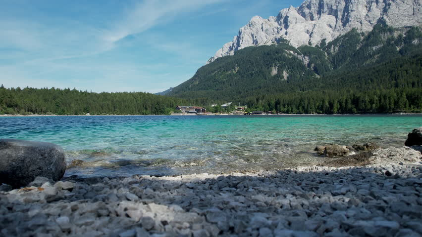 A beautiful Eibsee mountain lake with clear blue water and green trees. Bavarian region, Germany.