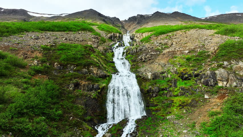 Scenic Mountain Waterfall Flowing Through Rocky Green Landscape