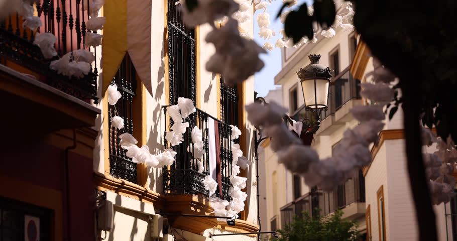Beautiful white garland hangs across the street in the historic old city of Seville, Andalusia, Spain.