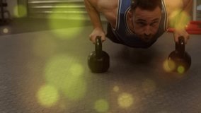 Male doing kettlebell pushups in high plank for strength at fitness gym, bokeh passing over him. Athlete, training, workout, power, endurance, focus, determination - Powered by Shutterstock - Get 15% off with code: PIKWIZARD15