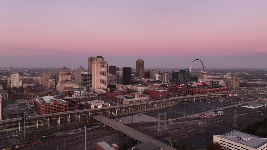 Aerial view of downtown Saint Louis, Missouri city at sunset with beautiful colors and tall buildings with the Gateway Arch.