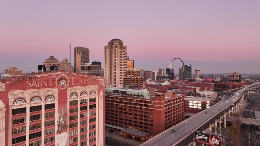 Aerial view of downtown Saint Louis, Missouri city at sunset with beautiful colors and tall buildings with the Gateway Arch.