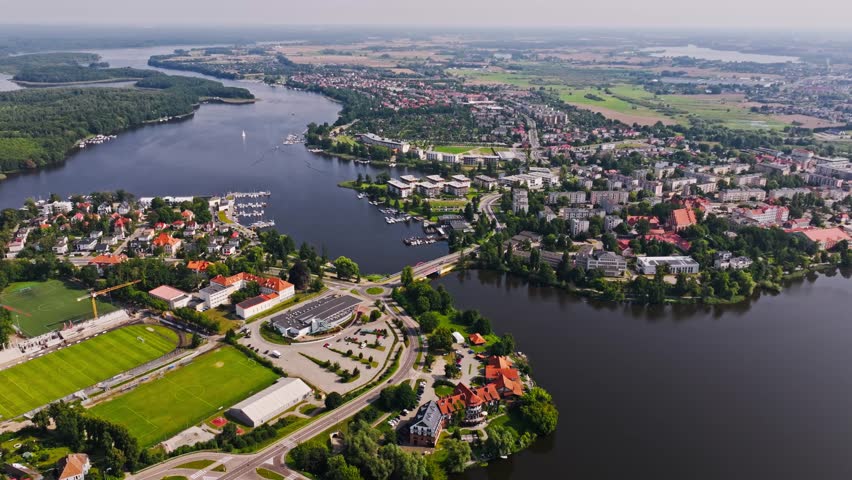 Summer aerial approach to Iława Poland showing lake shores and urban area