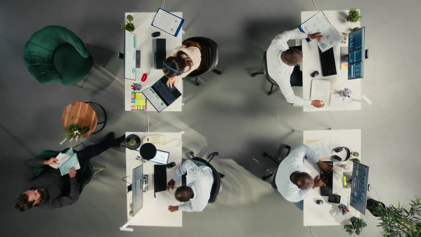 Office workers streamlining workflow with artificial intelligence, futuristic HUD icons symbolizing digital ecosystem. Top down view of colleagues using AI enterprise solutions driving business growth