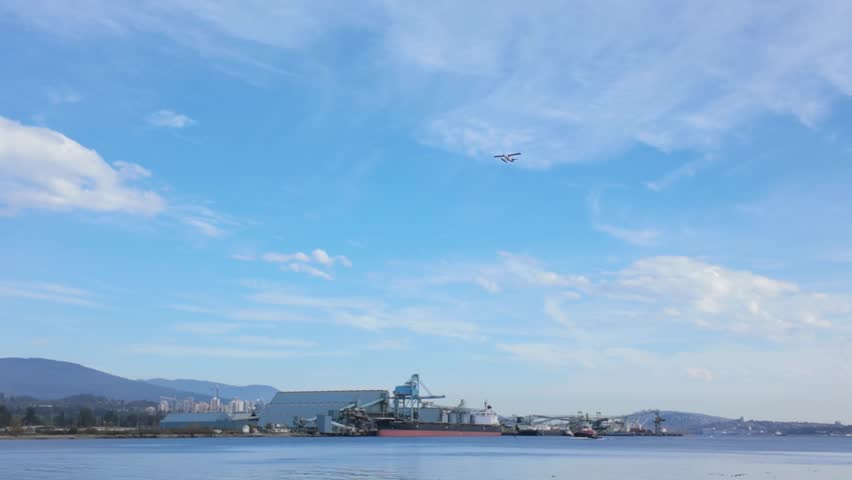 Gimbal wide tracking shot of a seaplane flying over Vancouver Harbour in British Columbia, Canada. 4K
