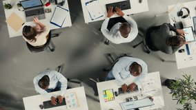 Collaborative team in company office sharing project files via cloud integration, digital ecosystem HUD icons. Aerial view of business colleagues syncing documents via online network on remote server - Powered by Shutterstock - Get 15% off with code: PIKWIZARD15