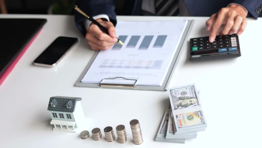 Investing in Real Estate, Real estate agent or investor calculating, planning, analyzing financial data for property investment. Themes of saving, investing, financial aspects of purchasing a home.