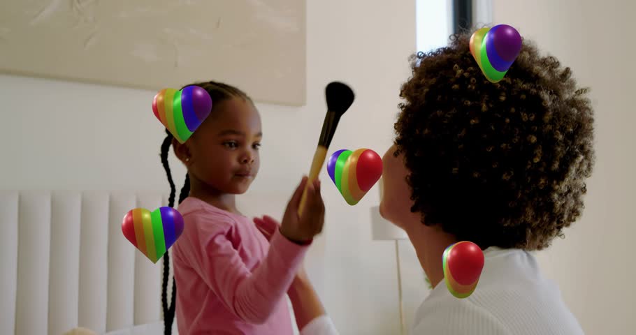 Daughter tapping brush on mother, practicing makeup education, rainbow hearts floating around them. Cosmetics, learning, bonding, girl, bedroom, family, candid