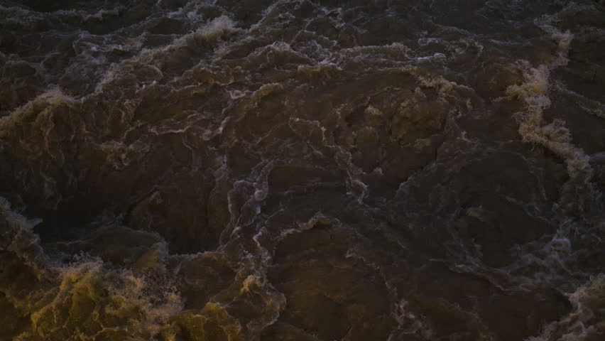 Turbulent Water Flow Beneath The Dam Gate, A professional documentary clip of water roaring under dam gate, spray misting in light, ideal for engineering marvel film or dynamic current documentary.